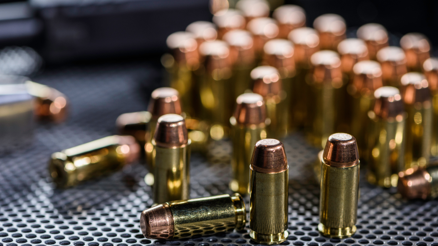 Close-up image of ammunition on a grate-like surface. Movers don't transport live ammunition, but full-service movers do transport firearms after an inspection and recording the serial number of the gun.