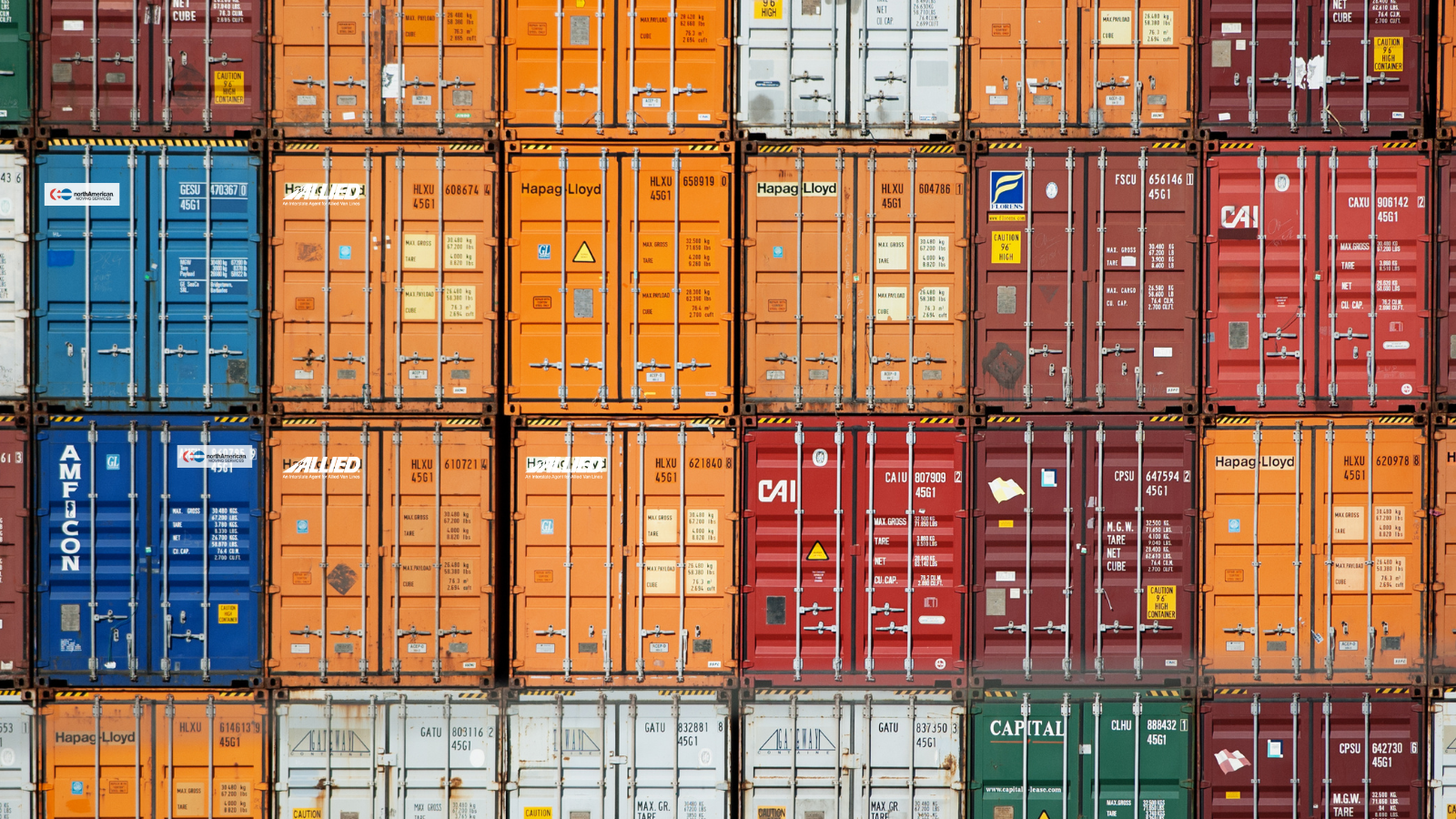 Image of many shipping containers stacked on one another. Image features orange Allied Van Lines containers and blue North American Van Lines shipping containers.