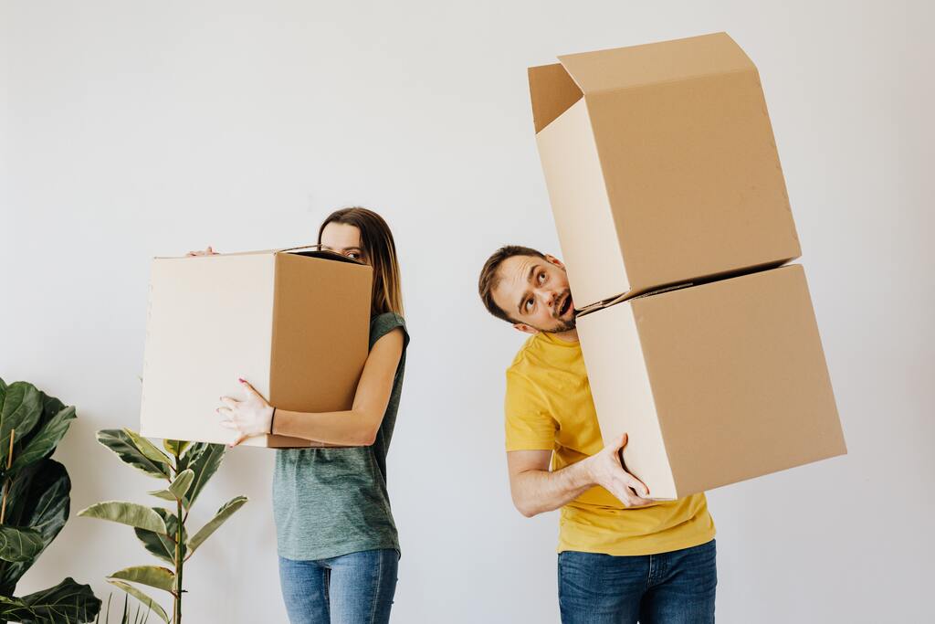couple holding moving boxes